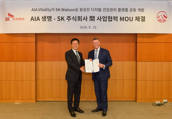 박정호 SK㈜ C&C 사장(사진 왼쪽)과 빌 라일 AIA 지역 총괄 CEO가 MOU 체결을 마무리하고 기념 사진을 찍고 있는 모습. 