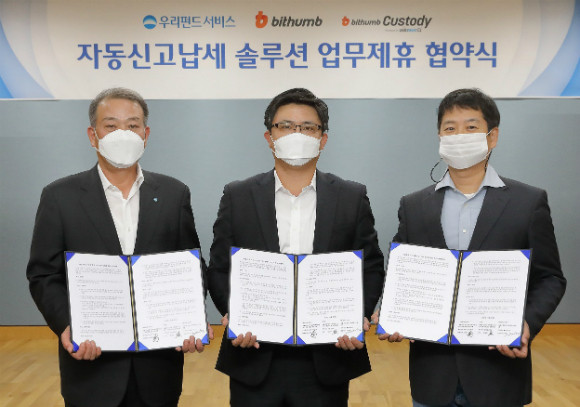 김영진 빗썸코리아 최고재무책임자(CFO·가운데), 신민철 볼트러스트 대표(오른쪽), 고영배 우리펀드서비스 대표(왼쪽)가 지난 10월 30일 서울시 마포구 우리금융상암센터에서 가상자산 자동신고납세 솔루션 공동개발 및 운영을 위한 업무제휴를 맺고 기념촬영을 하고 있다. /사진=빗썸코리아 