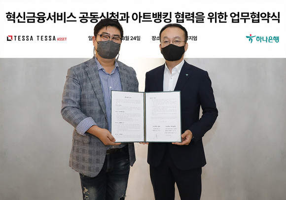  김기석 하나은행 자산관리그룹 부행장(사진 오른쪽)이 김형준 ㈜테사 대표(사진 왼쪽)와 함께 업무협약서를 들고 기념촬영을 하고 있다. 