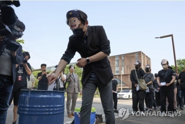 지난 5월15일 경기도 파주시 문발동 형설출판사 앞에서 열린 ‘검정고무신’ 장례 집회에서 이우영작가사건대책위원회가 펜그림을 태우며 고인을 추모하고 있다. [ⓒ 연합뉴스]