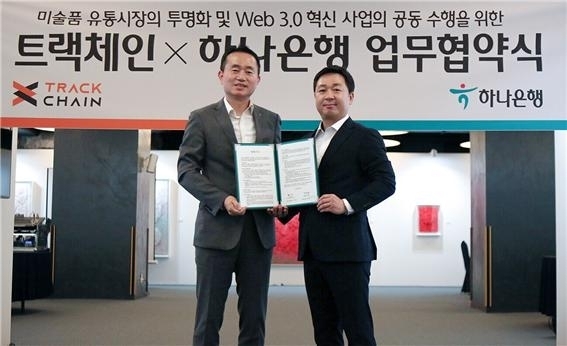 2023.7.3 하나은행과 트랙체인 ‘웹 Web 3.0’ 디지털 아트뱅킹 서비스 강화를 위한 업무협약 체결. 김영훈 하나은행 자산관리그룹장(사진 왼쪽)과 함성진 ㈜트랙체인 대표(사진 오른쪽)가 협약서를 들고 기념촬영을 하고 있다. ⓒ하나은행