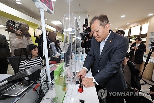 이상민 행정안전부 장관이 지난 19일 오후 서울 종로구 청운효자동주민센터를 방문해 정부 행정전산망 장애 복구를 위한 현장점검 도중 본인의 등본과 인감 서류를 발급하고 있다. [ⓒ 연합뉴스]