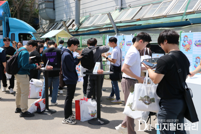 서머너즈 페스티벌 참가자들이 행사장 외부에서 피자를 즐기고 있다.