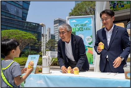 2024.6.11 농협금융 본사 광장에서 실시된 ‘NH-Ecycling Day’ 폐전자제품 기부행사에서 고장난 전자제품을 들고 참여한 아이에게 이석준 농협금융지주 회장(왼쪽), 이석용 농협은행 은행장(오른쪽)이 도넛을 나눠주고 있다. ⓒNH농협금융