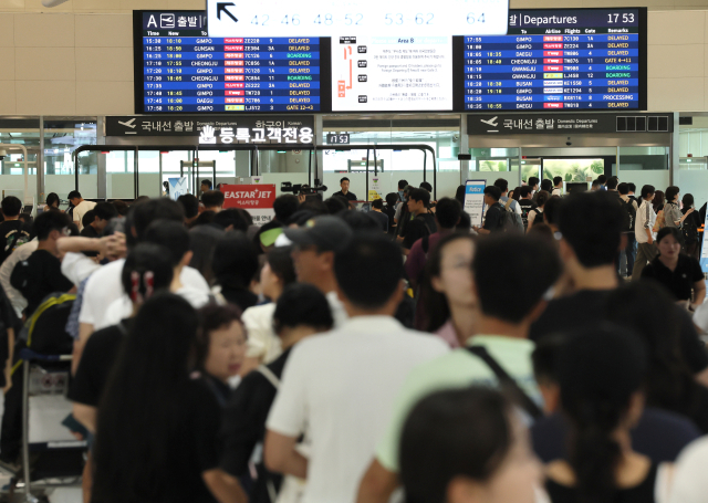 마이크로소프트(MS) 클라우드 오류로 일부 항공사 시스템이 멈춘 19일 제주국제공항 출발층에서 승객들이 발권을 위해 줄지어 서있다. [ⓒ연합뉴스]