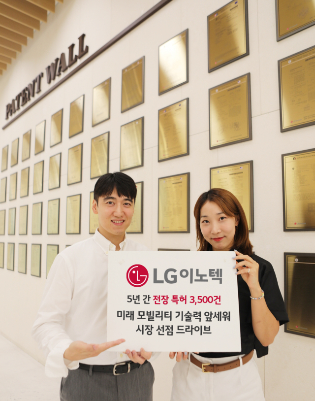 LG이노텍 본사 건물에 마련된 ‘Patent Wall’ 앞에서 직원들이 전장 특허 성과를 소개하고 있는 모습 [ⓒLG이노텍]