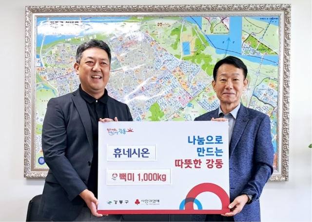 4일 ㈜휴네시온 최진석 전무(왼쪽)가 강동구청에 방문해 쌀 1000kg를 전달한 뒤 강동구청 손완현 복지가족국장과 기념촬영을 하고 있다. [ⓒ휴네시온]