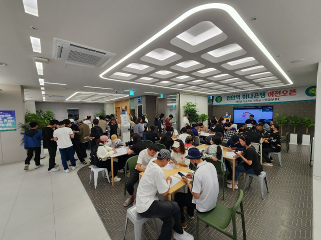 외국인들이 일요일 은행업무를 보기 위해 천안역 지점에 내점하여 순서를 기다리고 있다.ⓒ하나은행