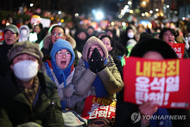 7일 오후 서울 여의도 국회 앞에서 열린 '내란죄 윤석열 퇴진! 국민주권 실현! 사회대개혁! 범국민촛불대행진'에서 참석자들이 김건희 특검법 부결 후, 민주당 박찬대 원내대표가 국민의힘 의원들을 호명하는 동안 눈물을 흘리고 있다. 2024.12.7 [ⓒ 연합뉴스]