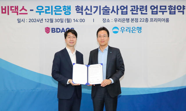 우리은행이 30일 은행 본점에서 비댁스와 혁신기술사업 관련 업무협약(MOU) 체결 후 (왼쪽부터) 류홍열 비댁스 대표, 옥일진 우리은행 디지털전략그룹장이 기념사진을 촬영하고 있다. ⓒ우리은행