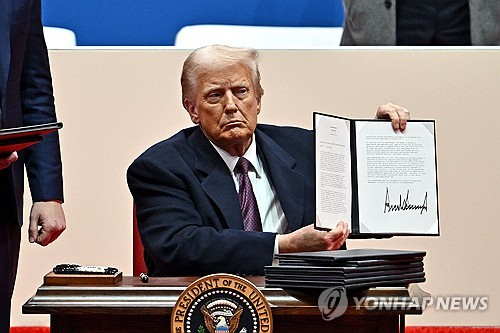 미국 대통령 도널드 트럼프가 2025년 1월 20일 워싱턴 DC 캐피털 원 아레나에서 열린 취임 퍼레이드 중 행정명령들에 서명하고 있다.[ⓒAFP=연합뉴스]