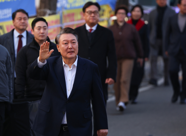 석방된 윤석열 대통령이 8일 경기도 의왕시 서울구치소 앞에서 경호차량에서 내려 걸어가며 지지자들에게 인사하고 있다. [ⓒ연합뉴스]