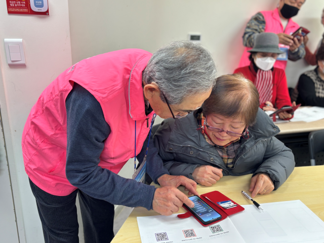 전년도 우수 수강생(왼쪽) 어르신이 보조강사로 활동하며 우리 어르신 IT 행복 배움교실 수업 수강생들을 돕고 있다. ⓒ우리금융